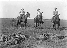 Capt. Monroe Fox and two other Rangers on horseback with their lariats around the bodies of dead Mexican bandits, after the Norias Ranch Raid August 8, 1915