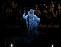 A projected image of a woman dancing slowly, wearing a white dress