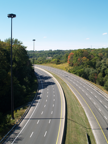 An empty six-lane highway in a forested valley