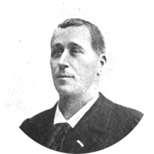 middle-aged white man, clean-shaven, with full head of neat dark hair; he is dressed in day clothes, with collar and tie