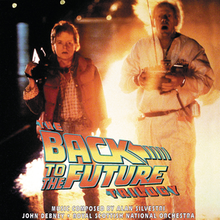 Michael J. Fox and Christopher Lloyd standing, with trails of fire behind them. The Back to the Future Trilogy logo is displayed in the center of the cover.