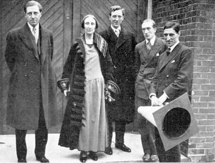 Group photograph with four clean-shaven white men and one woman in full-length frock