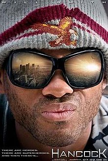 A closeup of Will Smith (as John Hancock) looking out towards the Los Angeles Skyline. His goggles show a reflection of the city with the sun setting. The film's tagline reads "THERE ARE HEROES. THERE ARE SUPERHEROES. AND THEN THERE's... HANCOCK"