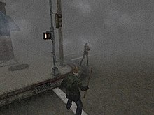 A screenshot from a video game. On the corner of a foggy street, a monster with no arms faces a man in a green jacket wielding a pipe.