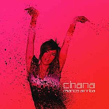 An image of Chana holding up her hands against a pink background. It has the words "Chana" and "Manos Arriba".