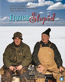 two men, dressed for ice fishing, sit on a bench on a frozen lake