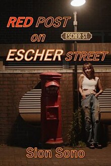 At night, a woman leans against a lamp post with the sign "Escher St". She is illuminated by the lamp's light. On the other side of the lamp post is a tall, red post box.