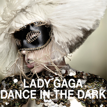Lady Gaga in a bob cut hairstyle wearing a black mask with strings around it on her eyes.