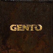 The cover art for "Gento": The song's title, "Gento", is written in gold material on top of a rusty brown background.